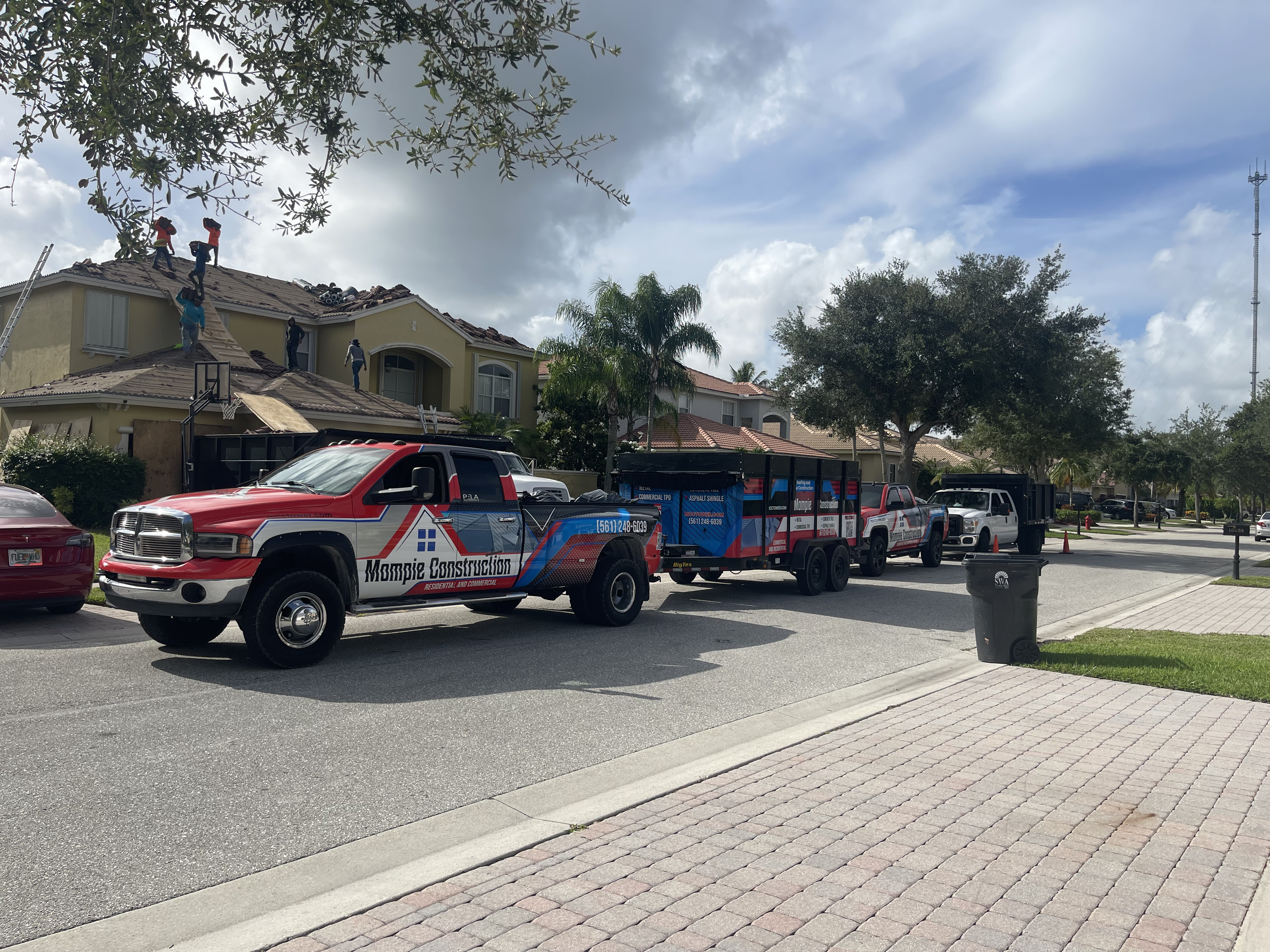 Mompie Construction fleet - roofing crew working on residential roof replacement in Palm Beach County