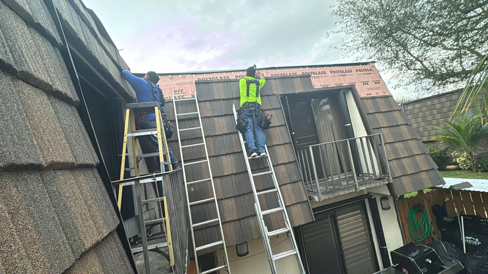 Roof crew installing shingles on two-story home Palm Springs FL